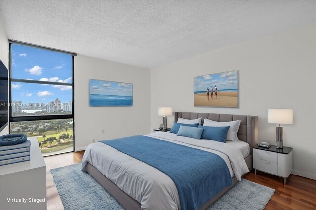 bedroom with floor to ceiling windows, a textured ceiling, and dark hardwood / wood-style flooring