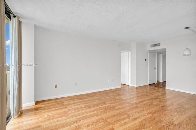 empty room featuring light hardwood / wood-style floors and a textured ceiling