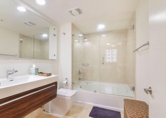 bathroom with tile flooring, vanity, and bath / shower combo with glass door