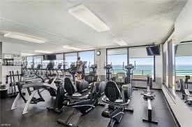 exercise room with a water view and expansive windows