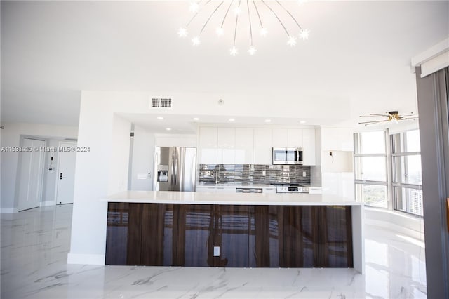 kitchen with backsplash, stainless steel appliances, white cabinets, and light tile floors