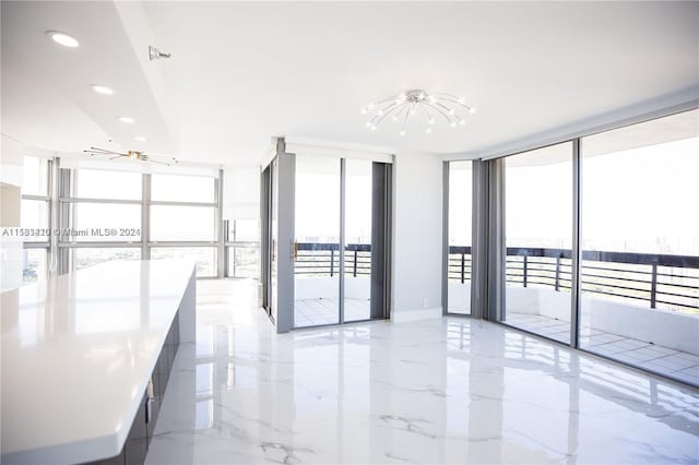 tiled spare room with a wall of windows and a chandelier