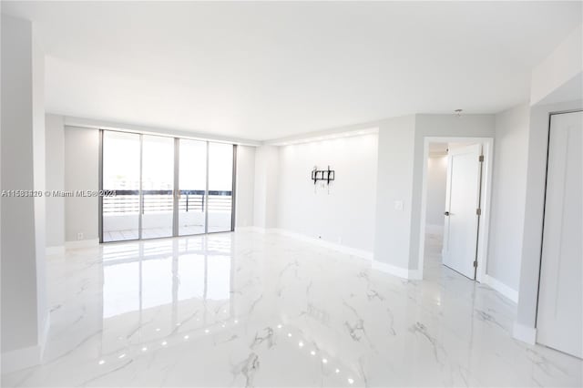 tiled spare room with a wall of windows