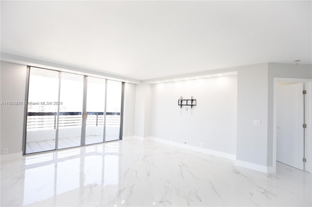 tiled spare room featuring expansive windows