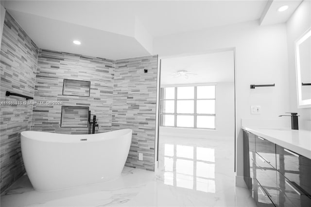 bathroom with tile flooring, sink, tile walls, and a tub