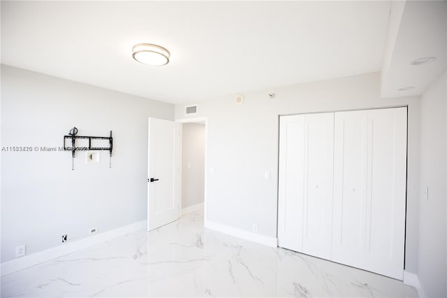 unfurnished bedroom featuring a closet and light tile flooring