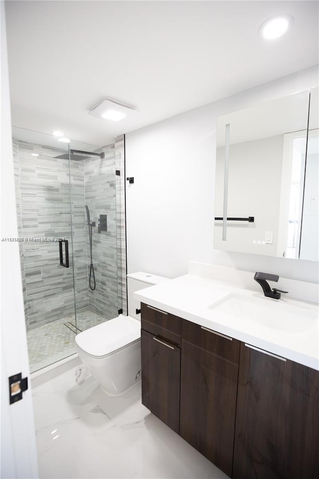 bathroom featuring a shower with door, toilet, and large vanity