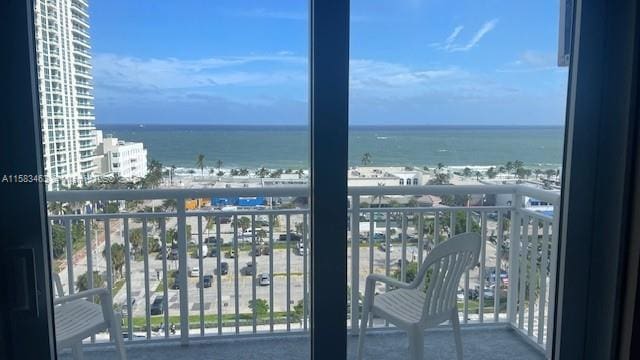 balcony featuring a water view and a city view