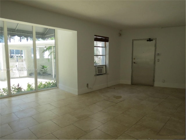 spare room featuring cooling unit and light tile patterned flooring