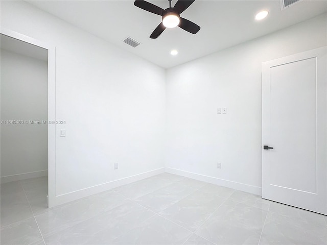 empty room with ceiling fan and light tile floors