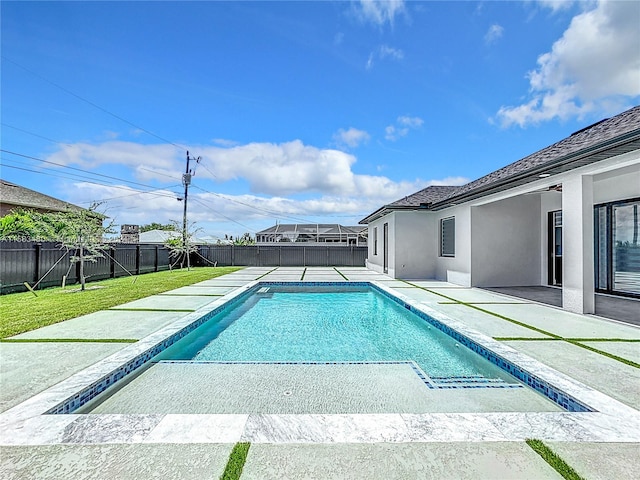 view of pool featuring glass enclosure, a yard, and a patio area