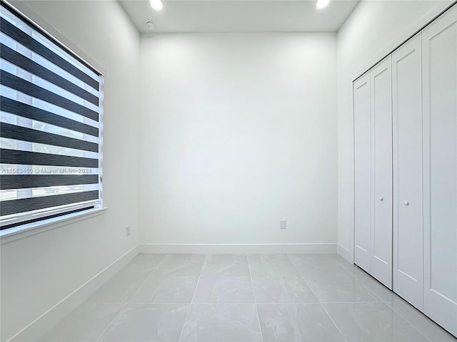 unfurnished bedroom with light tile floors