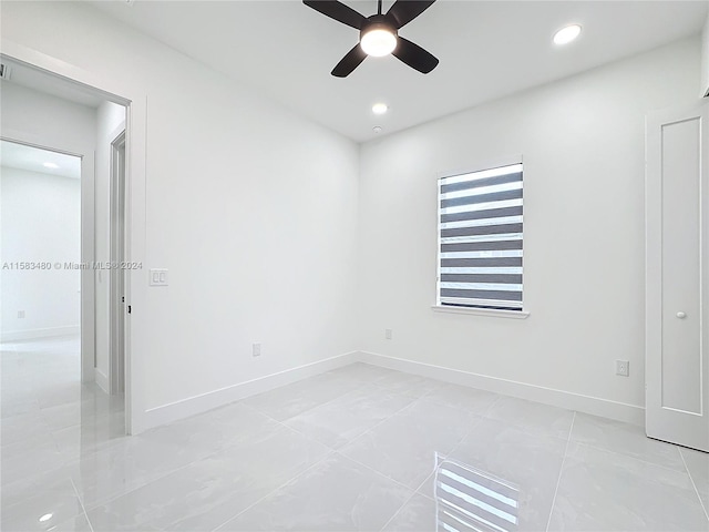 spare room featuring ceiling fan and light tile flooring