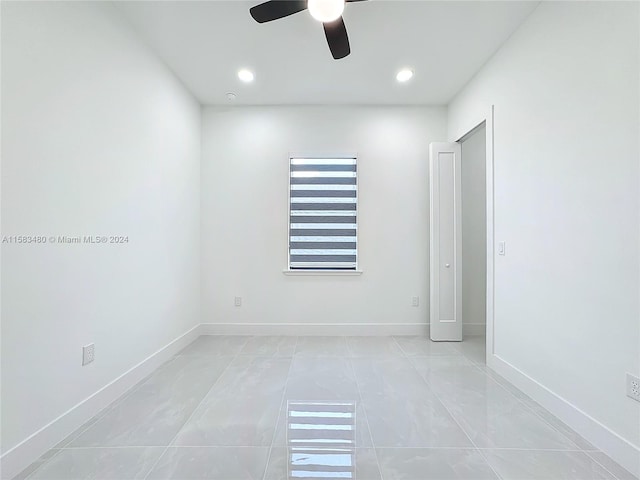 tiled spare room with ceiling fan