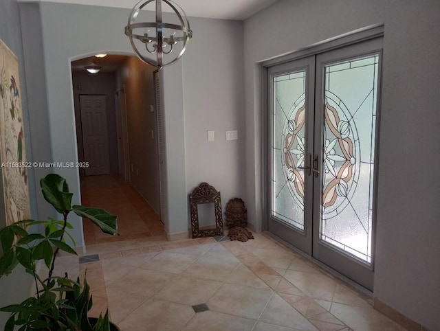 entrance foyer featuring light tile patterned floors, french doors, and a chandelier