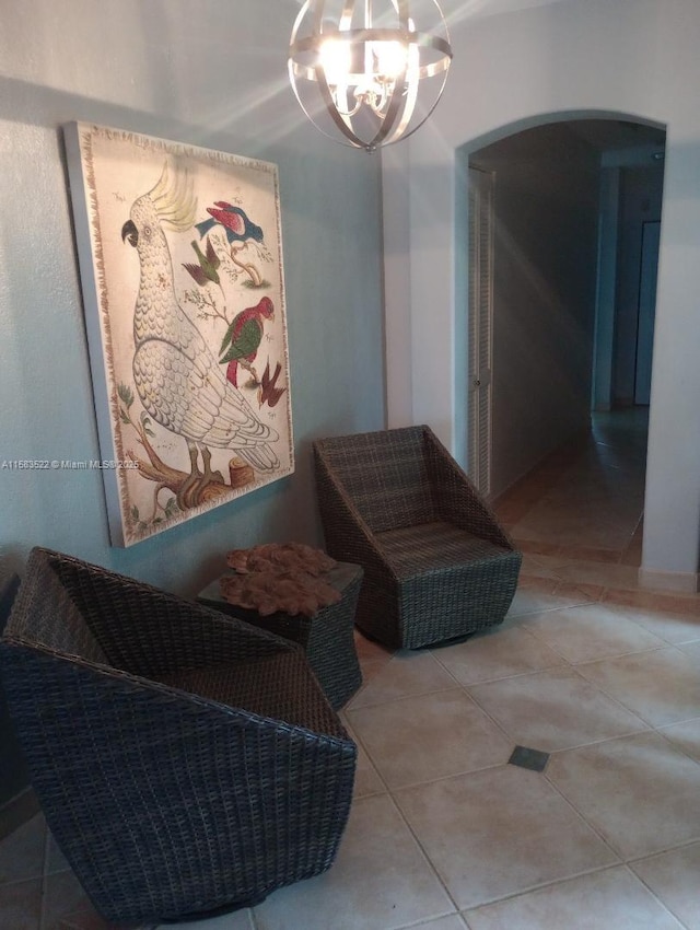 sitting room with a notable chandelier and light tile patterned flooring