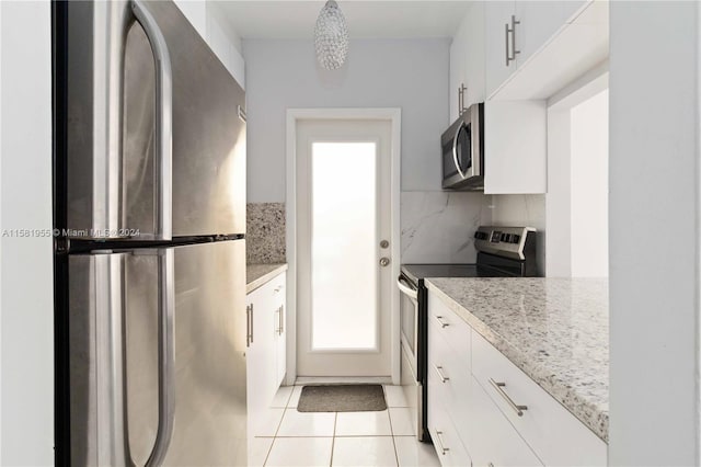 kitchen featuring light stone counters, white cabinetry, backsplash, and appliances with stainless steel finishes