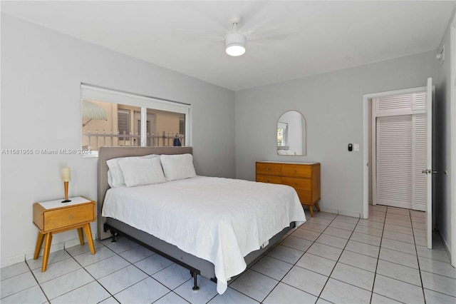 bedroom featuring ceiling fan, a closet, and light tile patterned floors