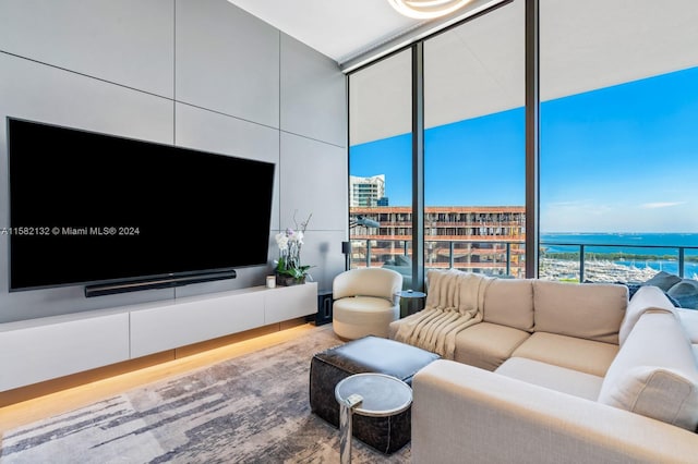 living room featuring hardwood / wood-style floors, a water view, and a wall of windows