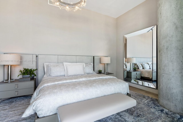 bedroom with hardwood / wood-style flooring and an inviting chandelier