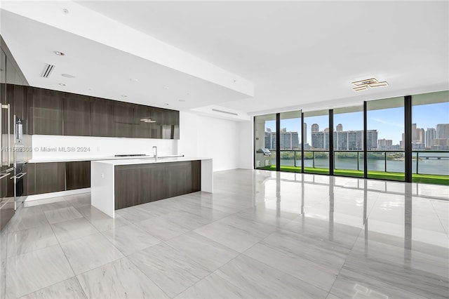 kitchen with a center island with sink and light tile floors