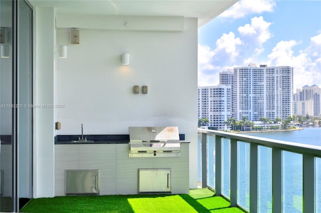 balcony with a grill, sink, and a water view