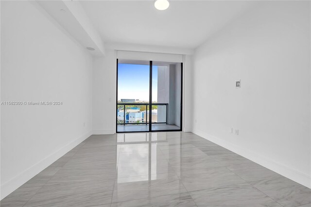 tiled spare room with floor to ceiling windows