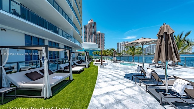 view of property's community with a patio area, a water view, a yard, and a pool