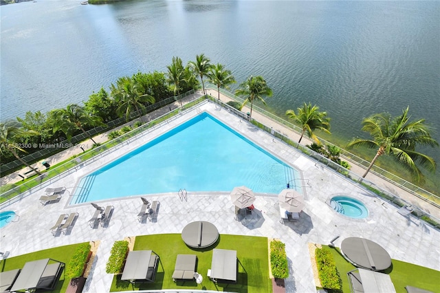 view of pool with a patio and a water view