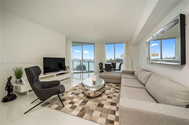 tiled living room with plenty of natural light, a water view, and a wall of windows