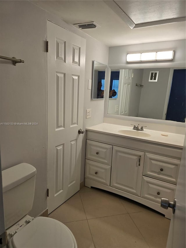 bathroom featuring toilet, vanity, and tile patterned floors