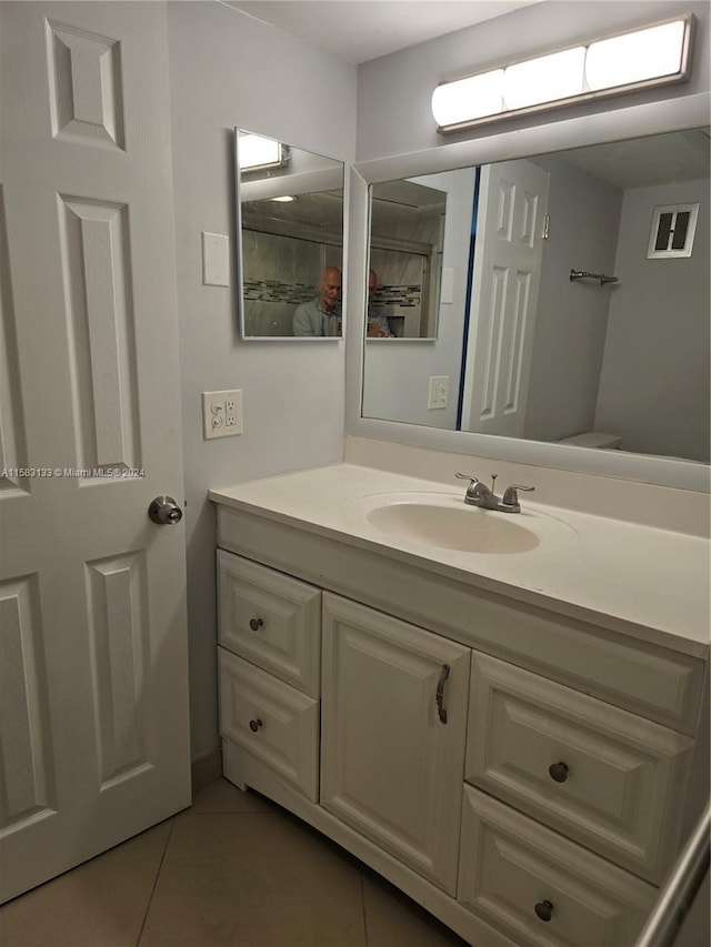 bathroom with tile patterned flooring, vanity, and toilet