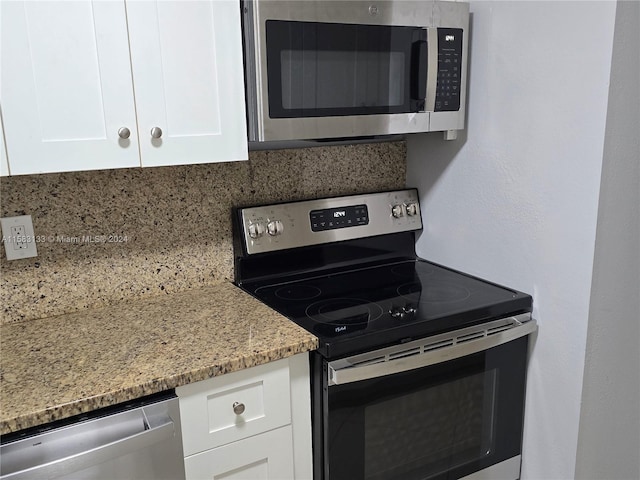 kitchen featuring light stone countertops, stainless steel appliances, white cabinetry, and tasteful backsplash