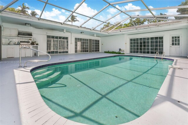 view of pool with a patio area, ceiling fan, and a lanai