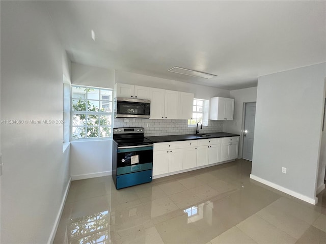 kitchen with a wealth of natural light, sink, light tile floors, and range with electric stovetop