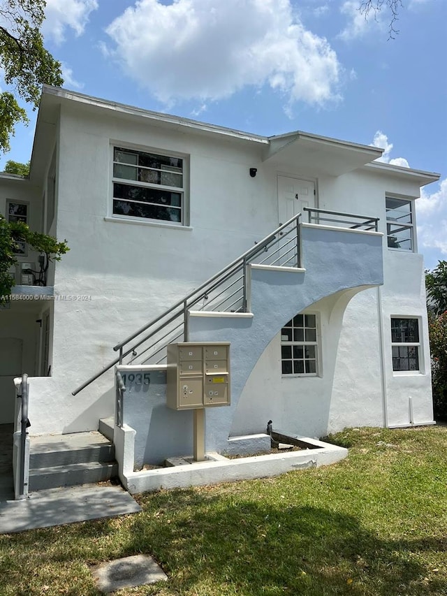 back of property featuring a yard and a balcony