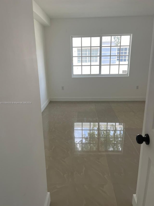 unfurnished room featuring tile flooring