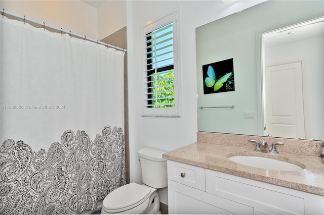 bathroom with vanity with extensive cabinet space and toilet