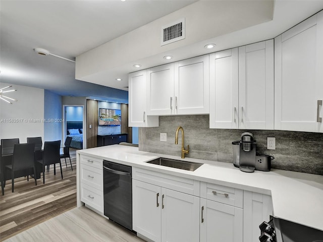 kitchen featuring sink, white cabinetry, light wood-type flooring, and black dishwasher