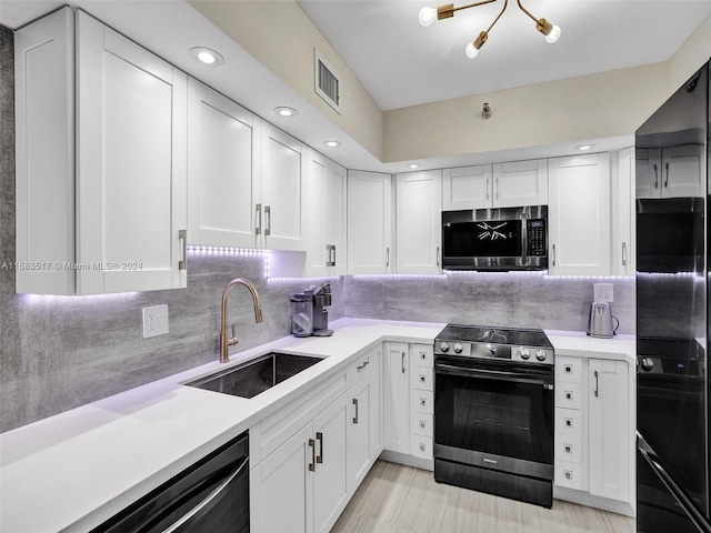 kitchen featuring backsplash, sink, white cabinetry, and black appliances