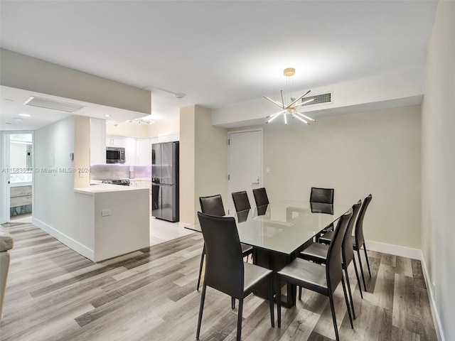 dining area featuring light hardwood / wood-style floors and an inviting chandelier