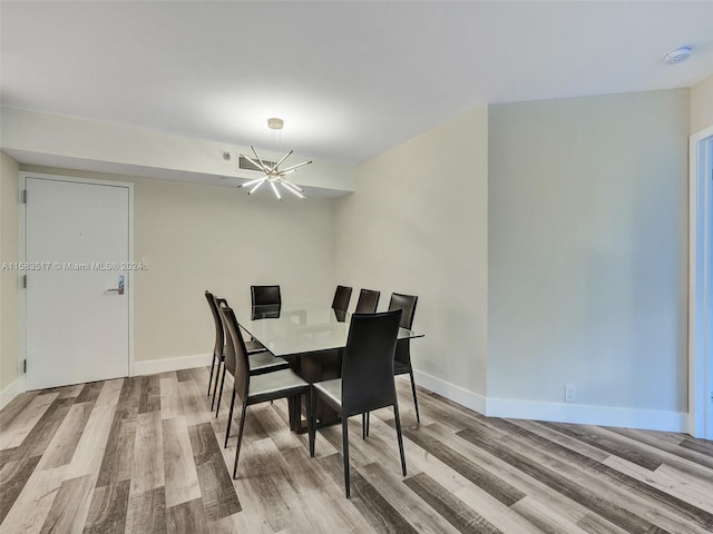 dining space featuring hardwood / wood-style floors and a notable chandelier