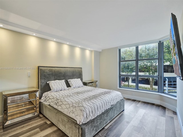 bedroom with hardwood / wood-style floors and multiple windows