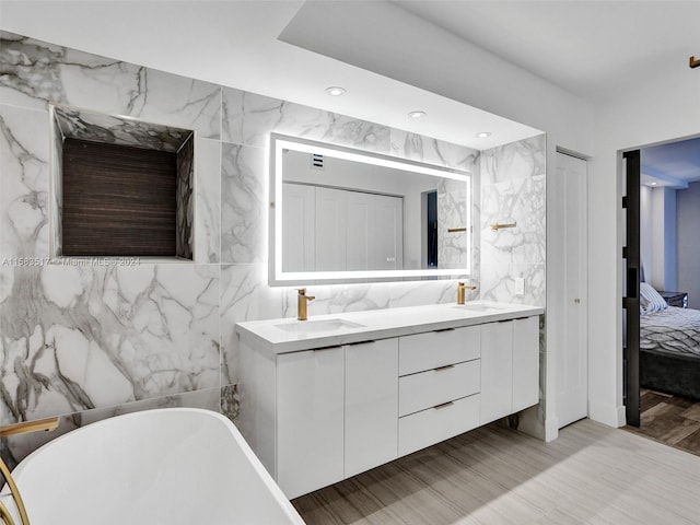 bathroom featuring wood-type flooring, tile walls, double sink, and large vanity