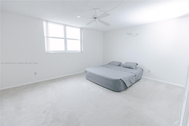 carpeted bedroom with a textured ceiling and ceiling fan