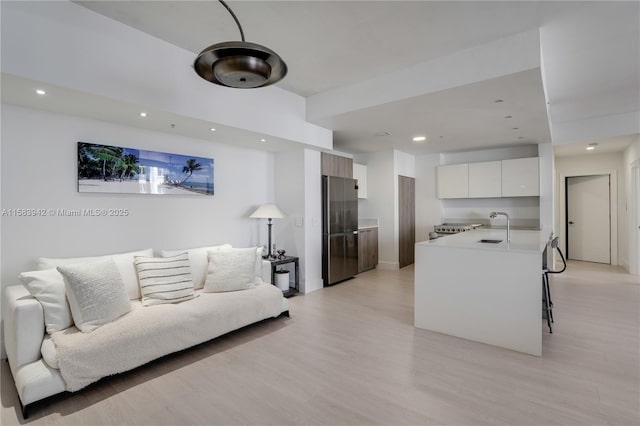 living area featuring light wood-type flooring and recessed lighting