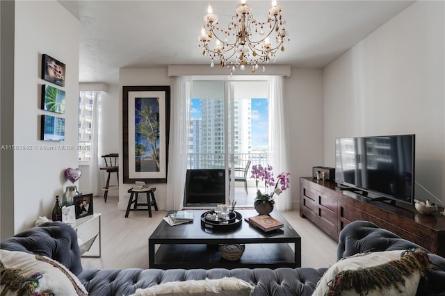 living room with light wood-style floors and a notable chandelier