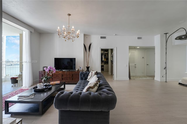 living room featuring light wood-style floors, visible vents, and baseboards