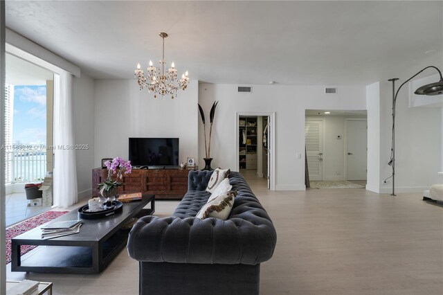 701 Brickell Key Blvd Unit Lph-06, Miami, FL 33131 - living area featuring a chandelier, light wood-style floors, and baseboards
