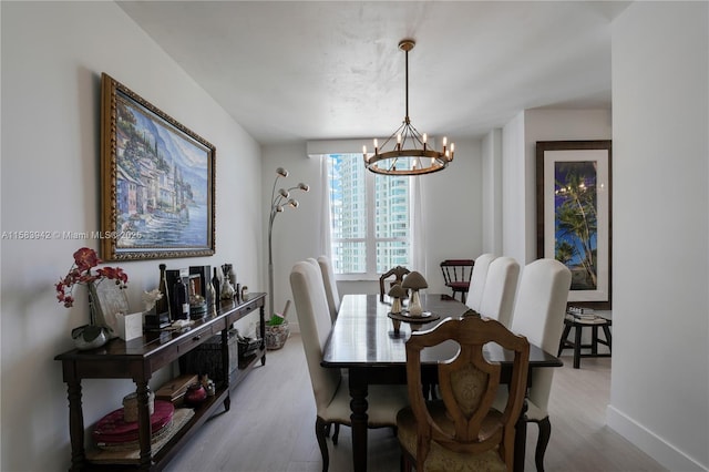 dining room featuring baseboards, an inviting chandelier, and light wood-style flooring